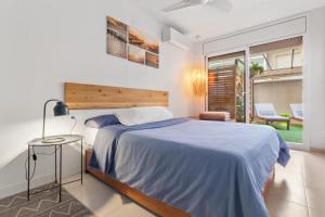 sypialnia z dużym łóżkiem i niebieskim kocem w obiekcie APARTMENT BIG PRIVAT TERRACE CALAFELL BEACH FREE Parking w mieście Calafell