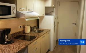eine Küche mit einem weißen Kühlschrank und einer Mikrowelle in der Unterkunft Bariloche Apart in San Carlos de Bariloche