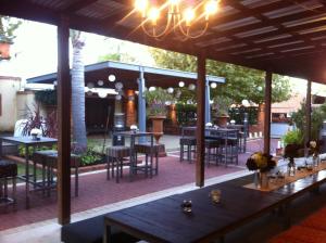 ein Restaurant mit Tischen und Stühlen auf einer Terrasse in der Unterkunft Rose & Crown Hotel in Perth