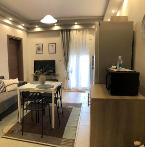 Il comprend une cuisine et un salon avec une table et des chaises. dans l'établissement Xenia_Apartments A6, à Kozani
