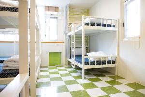 a room with bunk beds and a checkered floor at Happy Island Hostel in Ji'an