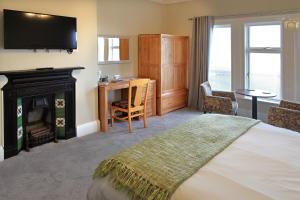 a bedroom with a bed with a fireplace and a television at The Marine Hotel in Hartlepool