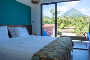 a bedroom with a bed and a view of a mountain at La Fortuna Lodge by Treebu Hotels in Fortuna