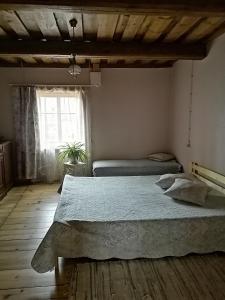 ein Schlafzimmer mit einem großen Bett und einem Fenster in der Unterkunft Dzirnavkalns in Cesvaine