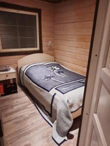 een kleine slaapkamer met een bed in een houten kamer bij Kärrända in Nedervetil