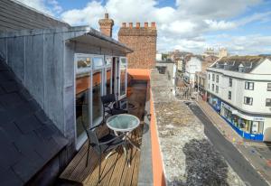 een balkon met een tafel en stoelen in een gebouw bij Stunning Central Exeter Apartment with balcony and fantastic view in Exeter