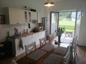 a kitchen with a table and chairs and a dining room at Pokoje Czajka- Agroturystyka in Ochotnica Górna