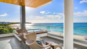 a balcony with chairs and a view of the ocean at Tranquility Beach Anguilla Resort in Meads Bay