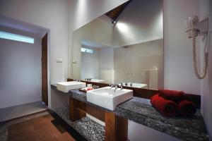 ASTON Sunset Beach Resort - Gili Trawangan في غيلي تراوانغان: حمام به مغسلتين ومرآة كبيرة