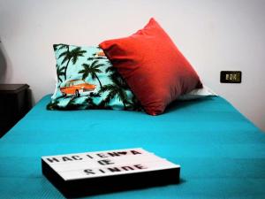 a book on a bed with a red pillow and a pillowparedangering at Belvilla by OYO Hacienda Lugar de Sinde in Val