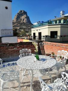 un tavolo bianco con sedie e una montagna sullo sfondo di Hotel Chely a Bernal