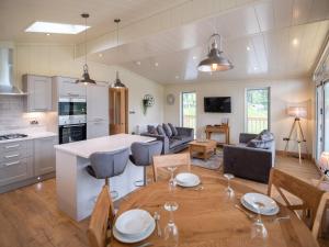 a kitchen and living room with a table and chairs at Otter Lodge in Skipton