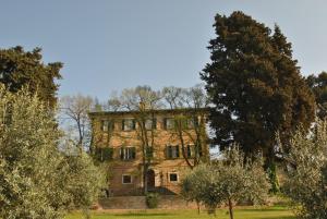een oud stenen huis midden tussen de bomen bij B&B Villa Dei Priori in Monsampolo del Tronto