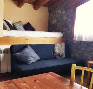 a bedroom with a bunk bed and a couch with a bed at Apartaments Cal Borda in Coll de Nargó