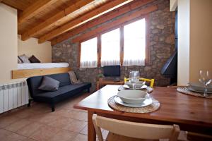 a living room with a table and a bed at Apartaments Cal Borda in Coll de Nargó