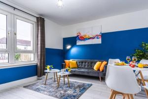 ein Wohnzimmer mit einem Sofa und einer blauen Wand in der Unterkunft Cheerful 2 Bedroom Homely Apartment, Sleeps 4 Guest Comfy, 1x Double Bed, 2x Single Beds, Free Parking, Free WiFi, Suitable For Business, Leisure Guest, Contractors, QE Hospital, Glasgow, Near Airport & City Centre in Glasgow + 33 Fotos