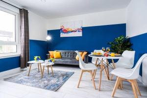 ein Wohnzimmer mit einer Couch und einem Tisch und Stühlen in der Unterkunft Cheerful 2 Bedroom Homely Apartment, Sleeps 4 Guest Comfy, 1x Double Bed, 2x Single Beds, Free Parking, Free WiFi, Suitable For Business, Leisure Guest, Contractors, QE Hospital, Glasgow, Near Airport & City Centre in Glasgow