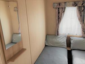 a small room with two beds and a window at Elder Standard Holiday Home in Ingoldmells