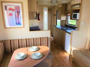 a small living room with a table and a kitchen at Elder Standard Holiday Home in Ingoldmells