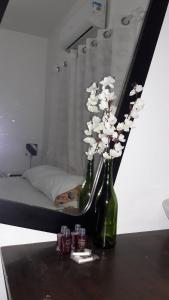 two green vases with white flowers on a table at Lolosa Suítes in Ubatuba +21 photos
