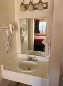 a bathroom with a sink and a mirror at Windsor Inn Lake Havasu City in Lake Havasu City