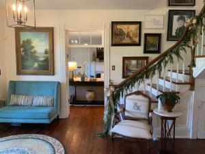 un salon avec un escalier et une chaise bleue dans l'établissement Historic Boyd Harvey House and Grounds, à Knoxville