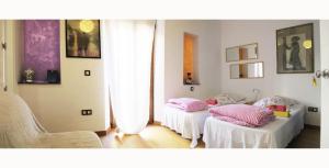 Pokój z 2 łóżkami i różowymi poduszkami w obiekcie B&B Casa Alfareria 59 w Sewilli