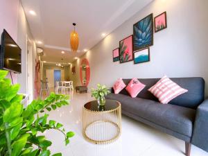 a living room with a blue couch and pink pillows at Luxury Cookies Apartment Vung Tau Gold Sea Melody in Vung Tau