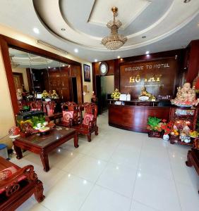 Hồ Tây Hotel في Thu Dau Mot: منطقة انتظار لفندق به طاولات وكراسي