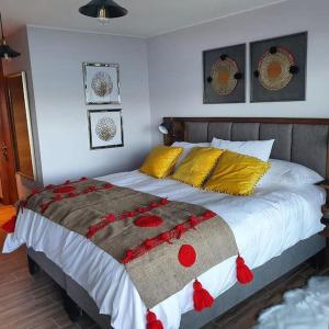 ein Schlafzimmer mit einem großen Bett mit einer Decke darauf in der Unterkunft Dpto Orilla Lago Villarrica Pucón Alwelafquen in Pucón