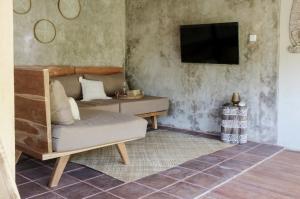 sala de estar con sofá y TV en Kokoi Villas en Kuta Lombok
