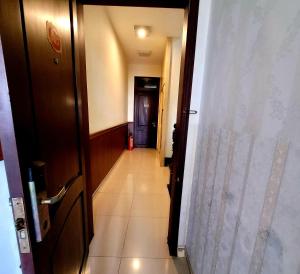 einen Flur, der zu einem Zimmer mit einer Tür führt in der Unterkunft Hồ Tây Hotel in Thu Dau Mot