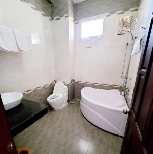 Hồ Tây Hotel في Thu Dau Mot: حمام ابيض مع مرحاض ومغسلة
