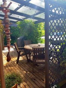 a wooden patio with a table and chairs on a wooden deck at Estuary Retreat Whangamata in Whangamata