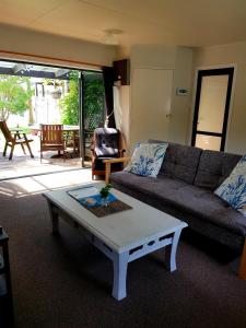 a living room with a couch and a coffee table at Estuary Retreat Whangamata in Whangamata