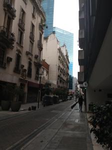 una persona caminando por una calle de la ciudad con edificios en Esmeralda en Buenos Aires