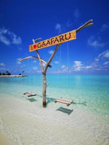 a tree on a beach with a sign that reads no gardenu at Mirian Sky in Gaafaru
