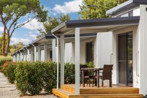 a row of white modular homes with a table and chairs at Gawler Caravan Park in Gawler