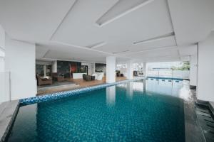 ein großer Pool mit blauem Wasser in einem Gebäude in der Unterkunft Platinum 1010 Studio Tera Apartemen Bandung City View in Bandung