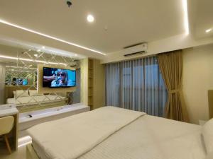 ein Schlafzimmer mit einem Bett und einem Fernseher an der Wand in der Unterkunft Platinum 1010 Studio Tera Apartemen Bandung City View in Bandung