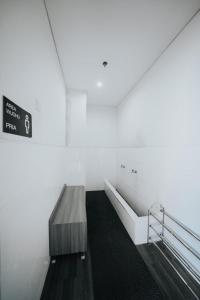 ein Badezimmer mit einer Bank und einem Schild an der Wand in der Unterkunft Platinum 1010 Studio Tera Apartemen Bandung City View in Bandung