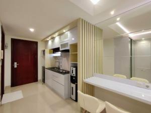 a kitchen with a counter and chairs in a room at Platinum 1012 Studio Tera Apartemen Bandung City View in Bandung