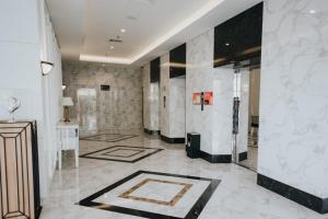 a lobby with white marble walls and a elevator at Platinum 1012 Studio Tera Apartemen Bandung City View in Bandung
