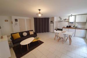 a living room with a couch and a table and a kitchen at Historical center of Pézenas in Pézenas