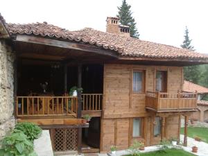 a log cabin with a deck and a balcony at Sarafova Guest House in Koprivshtitsa