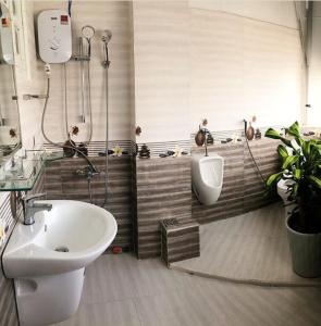 a bathroom with a sink and a toilet and a urinal at Lính Homestay Đà Lạt in Da Lat