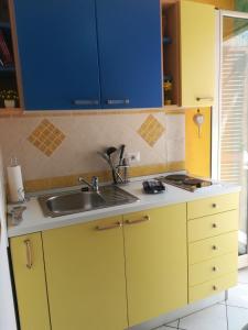 een keuken met gele kasten en een wastafel bij Antoinette in Gaeta