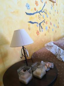 een tafel met een lamp en twee containers erop bij Antoinette in Gaeta