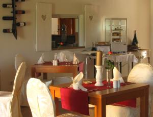 a living room with tables and chairs and a kitchen at Pension am Radweg & Ristorante Juani in Wriezen