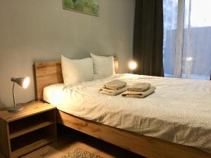 een slaapkamer met een bed met twee handdoeken erop bij Holdek Apartamenty Francuska in Katowice